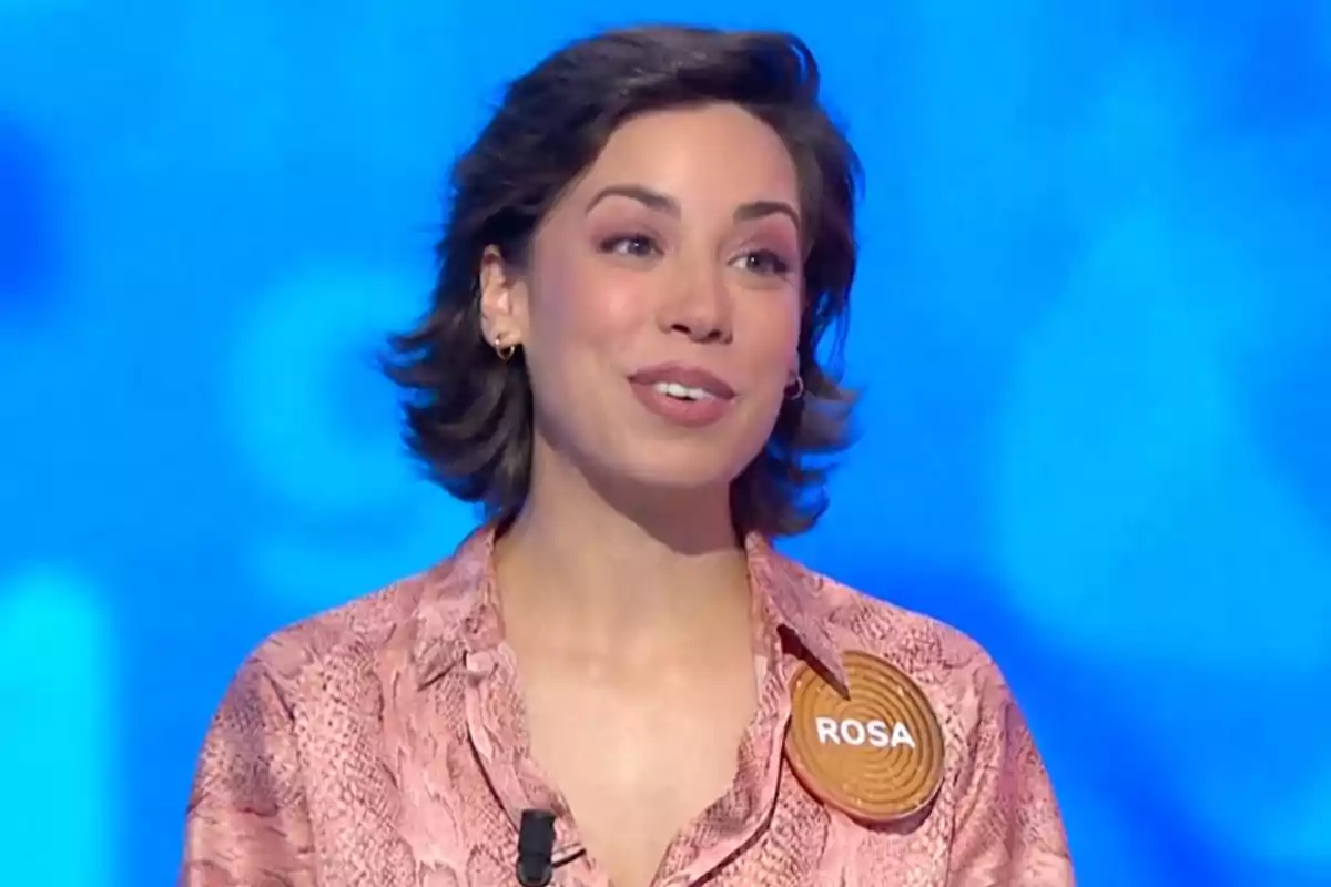 Rosa amb camisa rosa i una xapa que diu Rosa sobre un fons blau. Captura de 'Pasapalabra' Rosa amb camisa rosa i una xapa que diu Rosa sobre un fons blau. Captura de 'Pasapalabra'