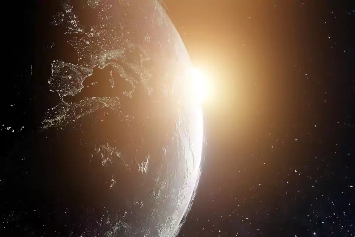 Vista del planeta Tierra desde el espacio con el sol asomando en el horizonte y Europa visible