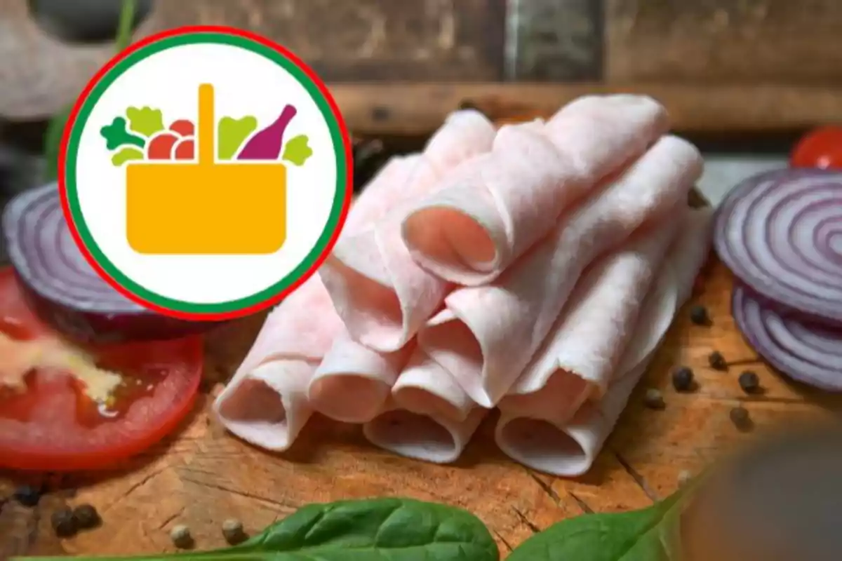 Llesques de pernil enrotllades sobre una taula de fusta al costat de rodanxes de tomàquet, ceba morada i fulles verdes amb una icona de cistell de supermercat a la cantonada superior esquerra Llesques de pernil enrotllades sobre una taula de fusta al costat de rodanxes de tomàquet, ceba morada i fulles verdes amb una icona de cistell de supermercat a la cantonada superior esquerra