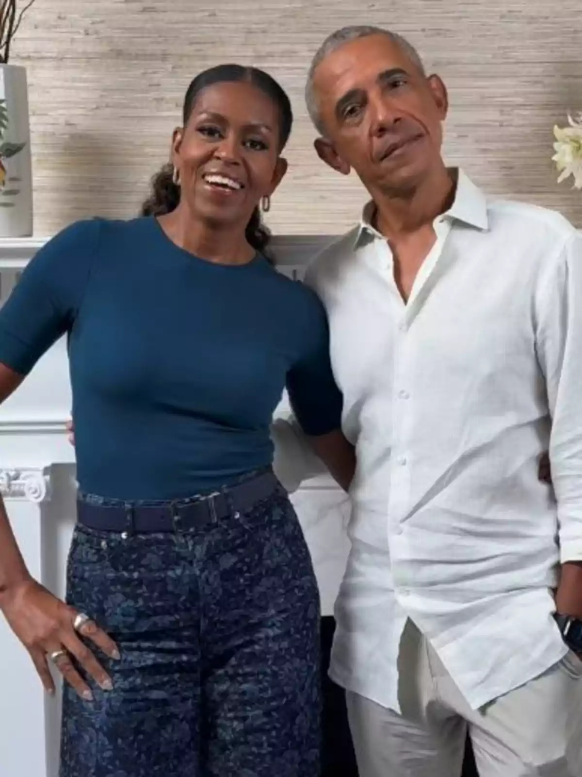 Michelle y Barack Obama sonriente posa abrazada frente a una chimenea decorada con flores Michelle y Barack Obama sonriente posa abrazada frente a una chimenea decorada con flores