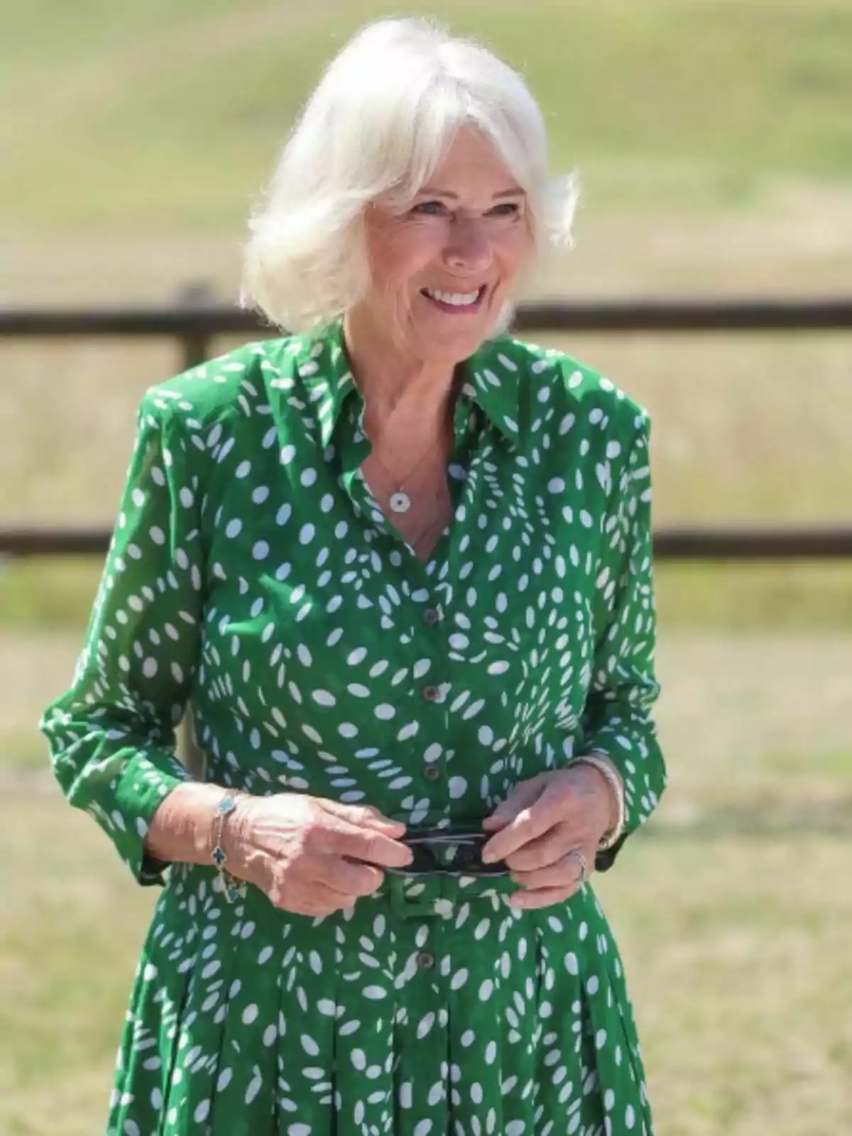 La reina Camila somrient amb vestit verd de punts blancs en un entorn a l’aire lliure La reina Camila somrient amb vestit verd de punts blancs en un entorn a l’aire lliure