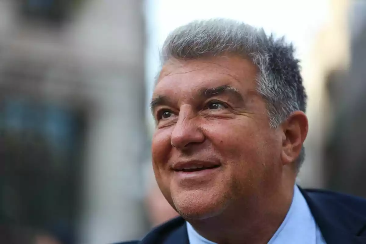 Hombre de cabello canoso y sonrisa vistiendo traje oscuro en un entorno urbano desenfocado Hombre de cabello canoso y sonrisa vistiendo traje oscuro en un entorno urbano desenfocado
