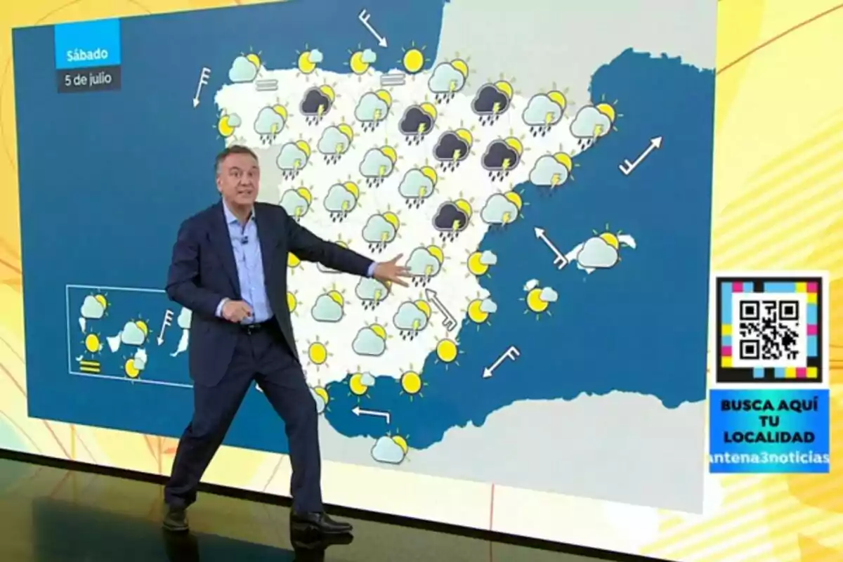 Roberto Brasero assenyalant un mapa d’Espanya amb símbols meteorològics de sol, núvols i pluges, al costat d’un codi QR i un requadre blau que convida a cercar la localitat. Roberto Brasero assenyalant un mapa d’Espanya amb símbols meteorològics de sol, núvols i pluges, al costat d’un codi QR i un requadre blau que convida a cercar la localitat.