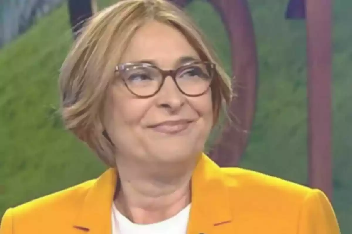 Rosa Lerchundi de cabell curt i ros amb ulleres i jaqueta groga somrient en un entorn d’estudi d’Informatius Telecinco Rosa Lerchundi de cabell curt i ros amb ulleres i jaqueta groga somrient en un entorn d’estudi d’Informatius Telecinco