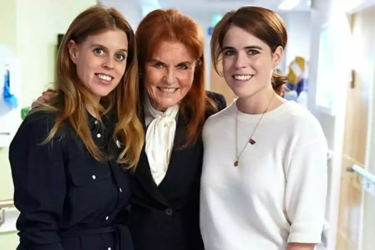 Tres dones somriuen i posen juntes en un passadís il·luminat Tres dones somriuen i posen juntes en un passadís il·luminat