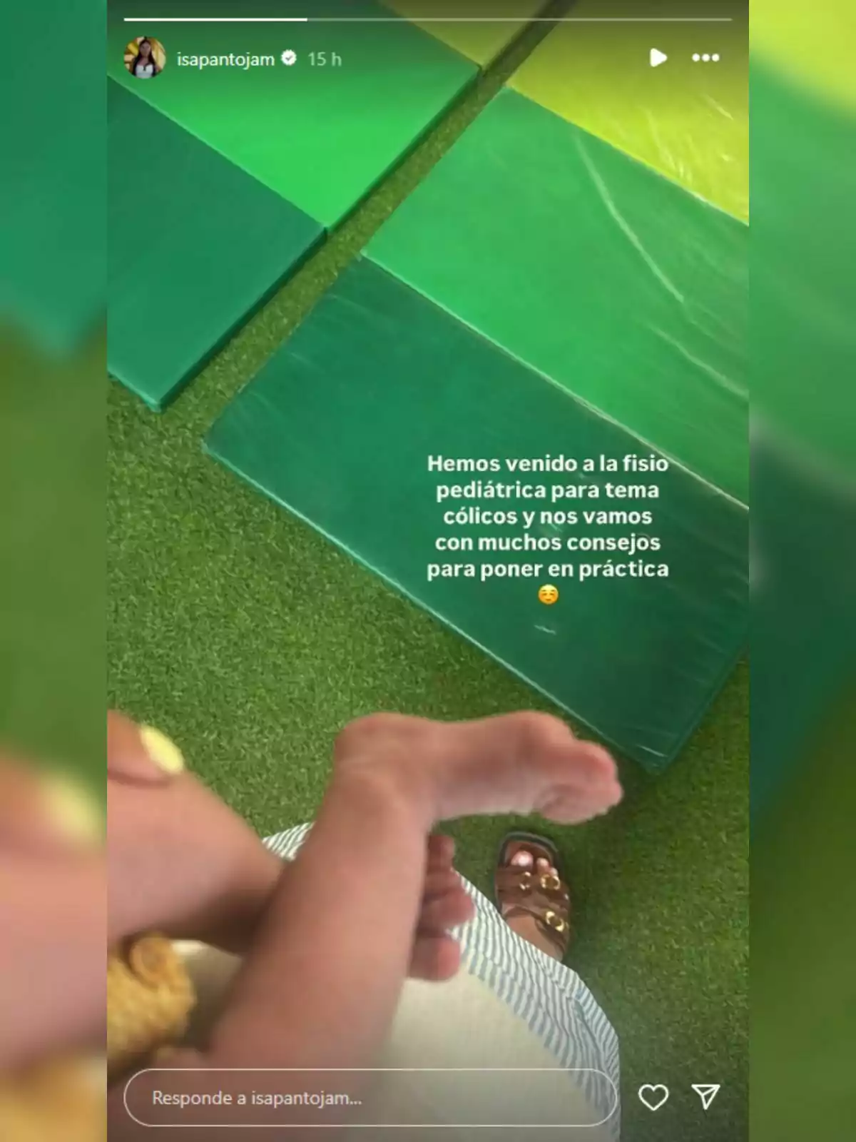 Isa Pantoja sosté un nadó en una sala amb matalassets verds i gespa artificial, mentre es llegeix un missatge sobre una visita a fisioteràpia pediàtrica. Isa Pantoja sosté un nadó en una sala amb matalassets verds i gespa artificial, mentre es llegeix un missatge sobre una visita a fisioteràpia pediàtrica.