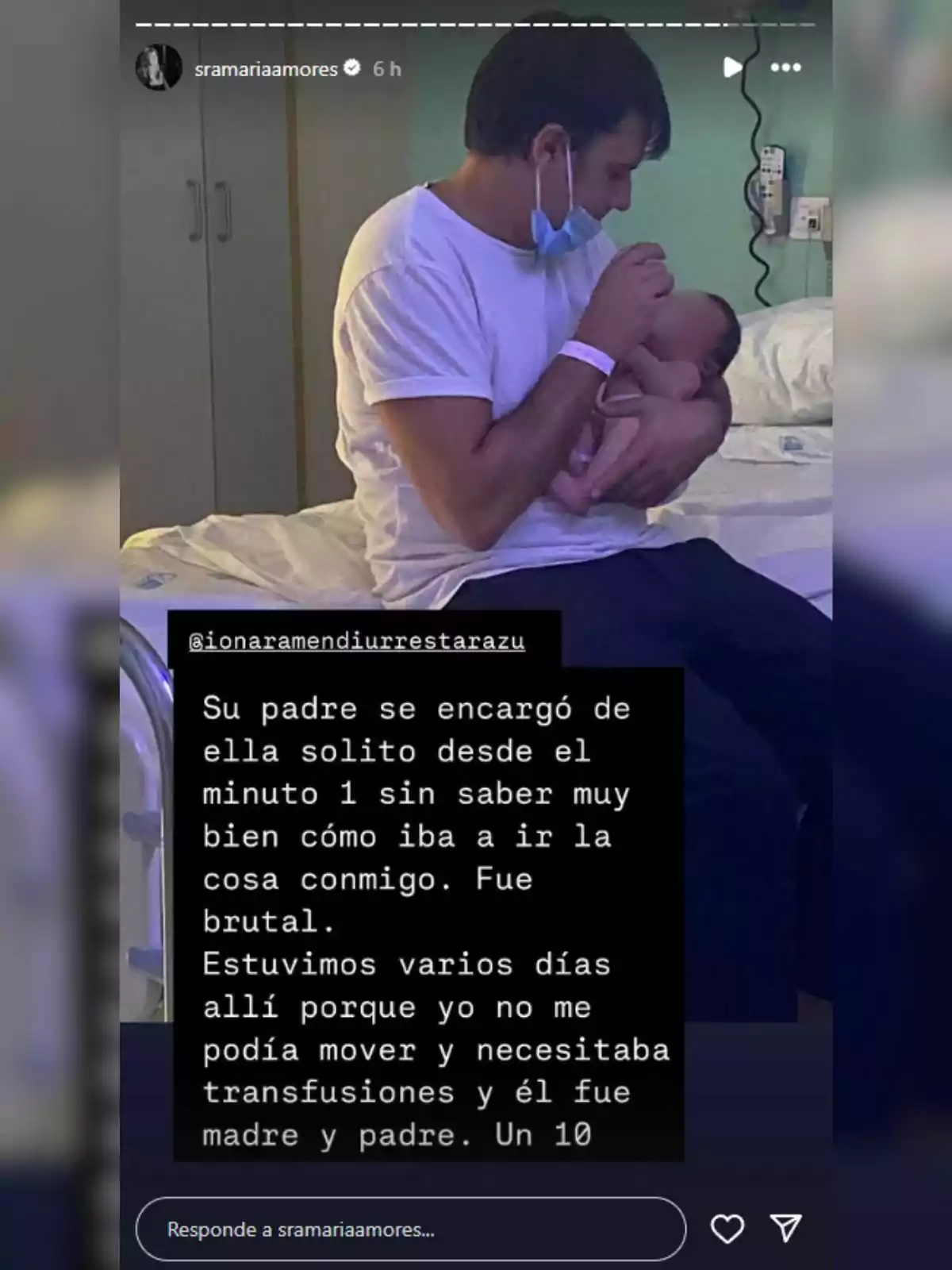 Ion Aramendi con camiseta blanca sostiene y alimenta a un bebé en una habitación de hospital, mientras lleva una mascarilla bajada al cuello y una pulsera de paciente en la muñeca. Ion Aramendi con camiseta blanca sostiene y alimenta a un bebé en una habitación de hospital, mientras lleva una mascarilla bajada al cuello y una pulsera de paciente en la muñeca.