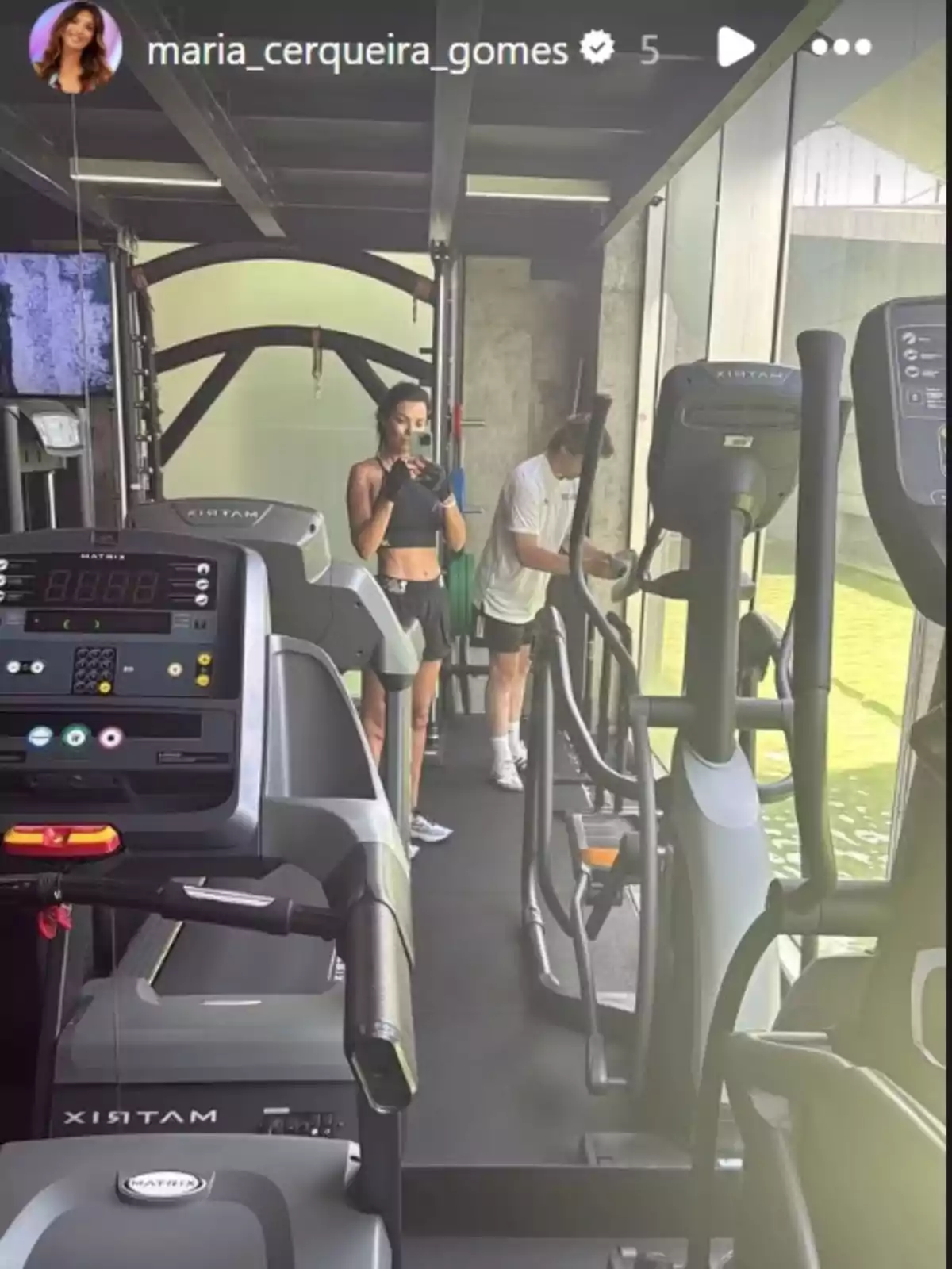 Selfie de María Cerqueira, donde se la ve dentro de un gimnasio, junto a otro hombre y rodeada de máquinas Selfie de María Cerqueira, donde se la ve dentro de un gimnasio, junto a otro hombre y rodeada de máquinas