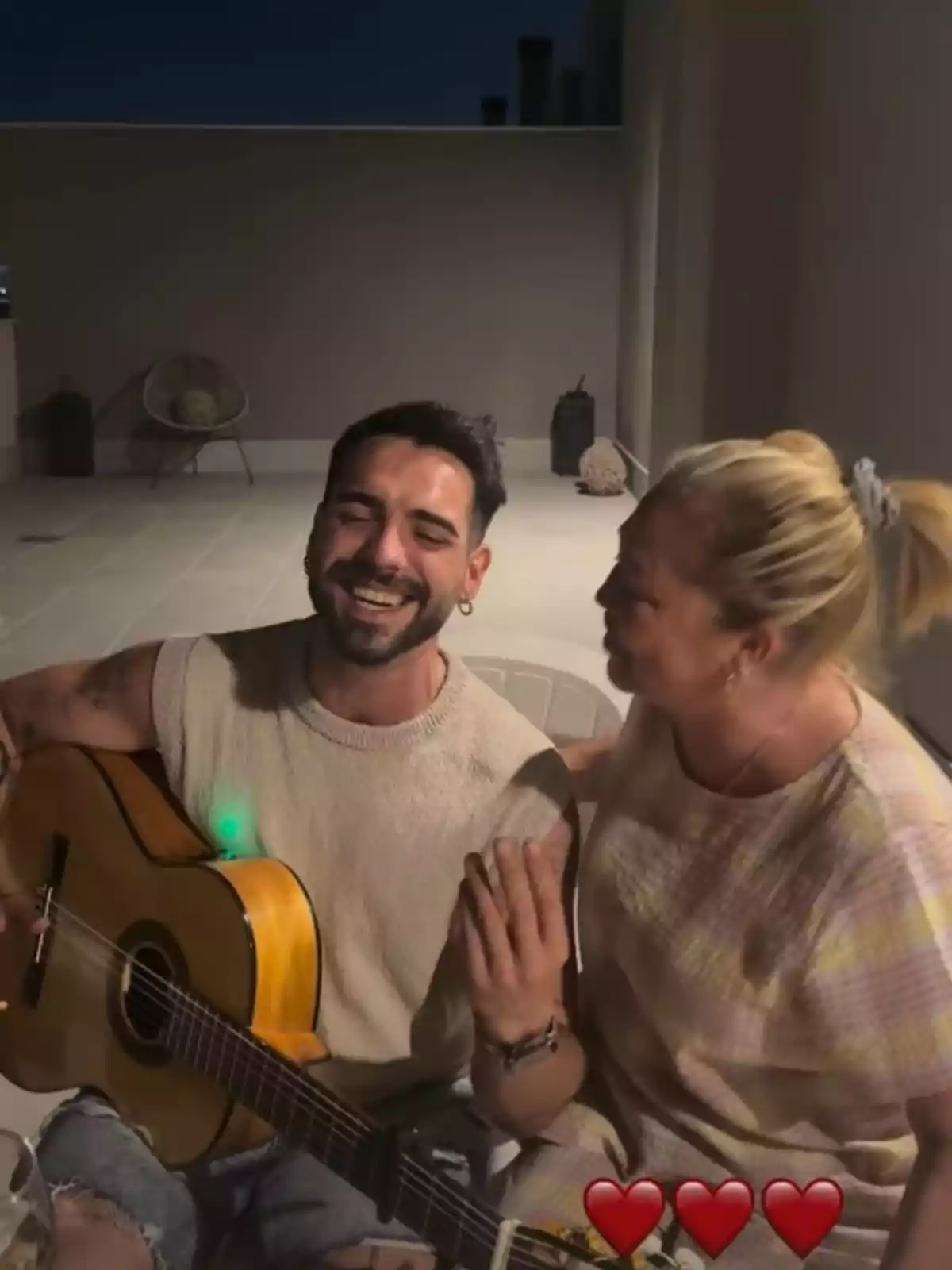 Alejandro Caraza, con una guitarra, y Belén Esteban sonríen mientras cantan una canción Alejandro Caraza, con una guitarra, y Belén Esteban sonríen mientras cantan una canción