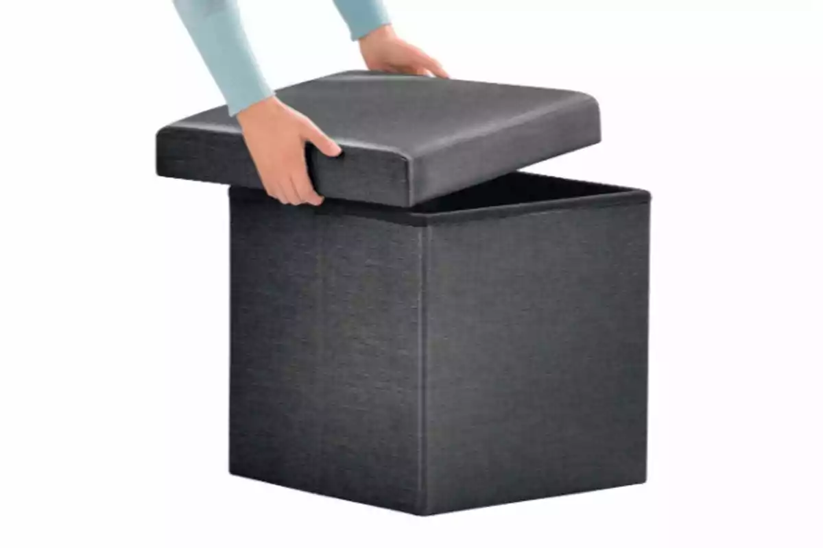 Persona aixecant la tapa d’un banc organitzador de tela de color gris Persona aixecant la tapa d’un banc organitzador de tela de color gris
