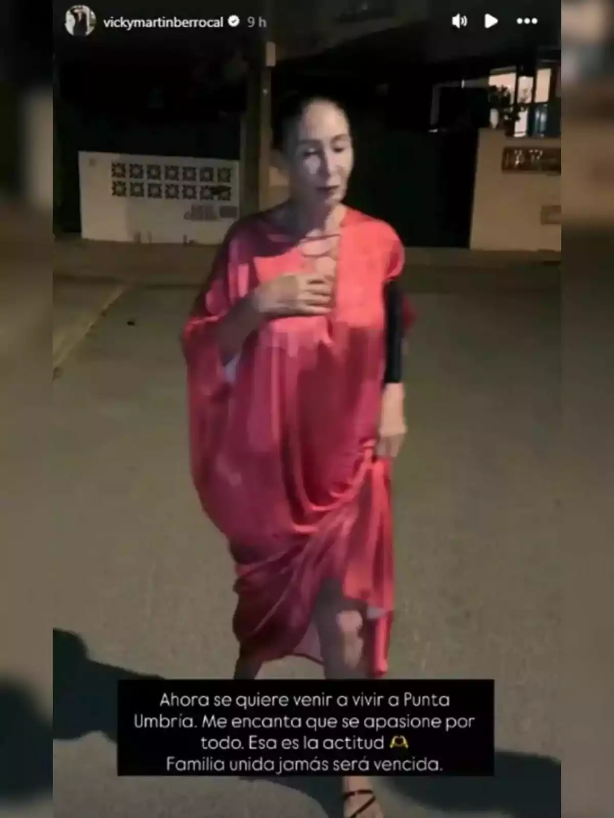 Vicky Martín Berrocal de pie en la calle durante la noche vistiendo un vestido rosa, con un texto en la parte inferior que habla sobre mudarse a Punta Umbría y la importancia de la familia unida. Vicky Martín Berrocal de pie en la calle durante la noche vistiendo un vestido rosa, con un texto en la parte inferior que habla sobre mudarse a Punta Umbría y la importancia de la familia unida.