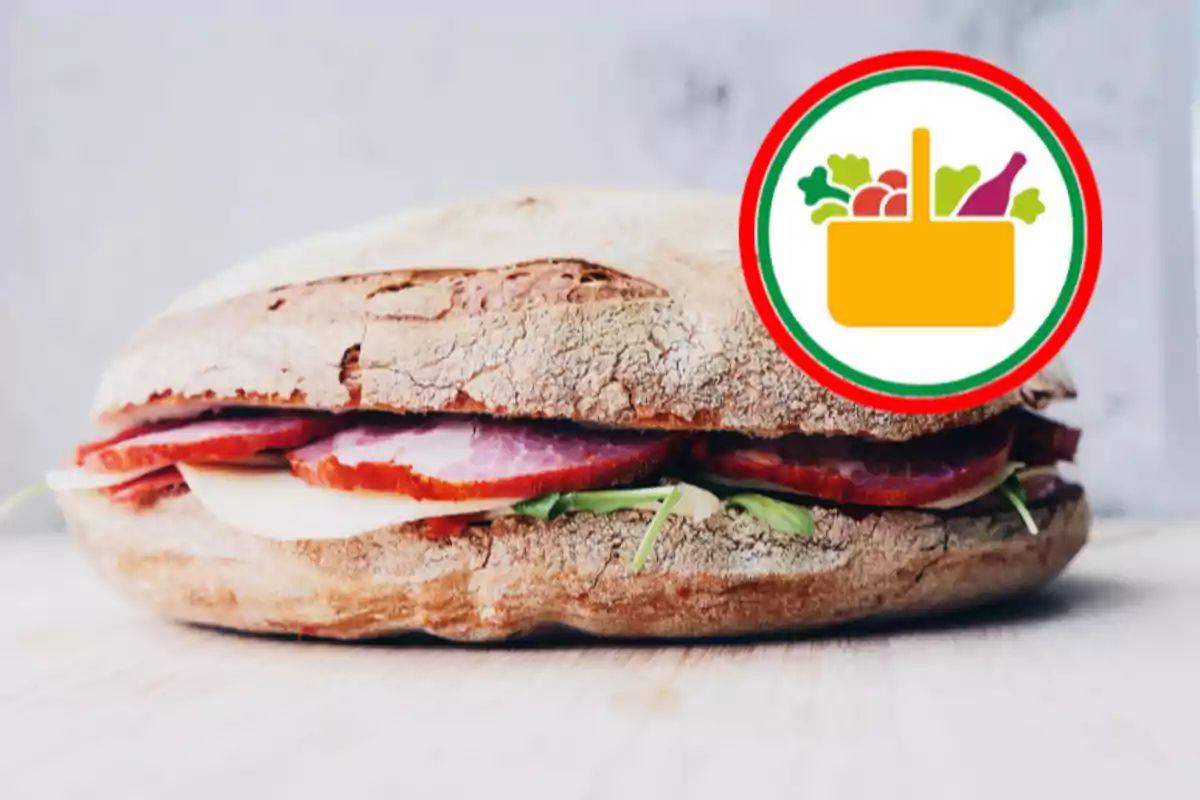 Un entrepà de pa rústic amb pernil, formatge i verdures al costat d’una icona de cistell de supermercat Un entrepà de pa rústic amb pernil, formatge i verdures al costat d’una icona de cistell de supermercat