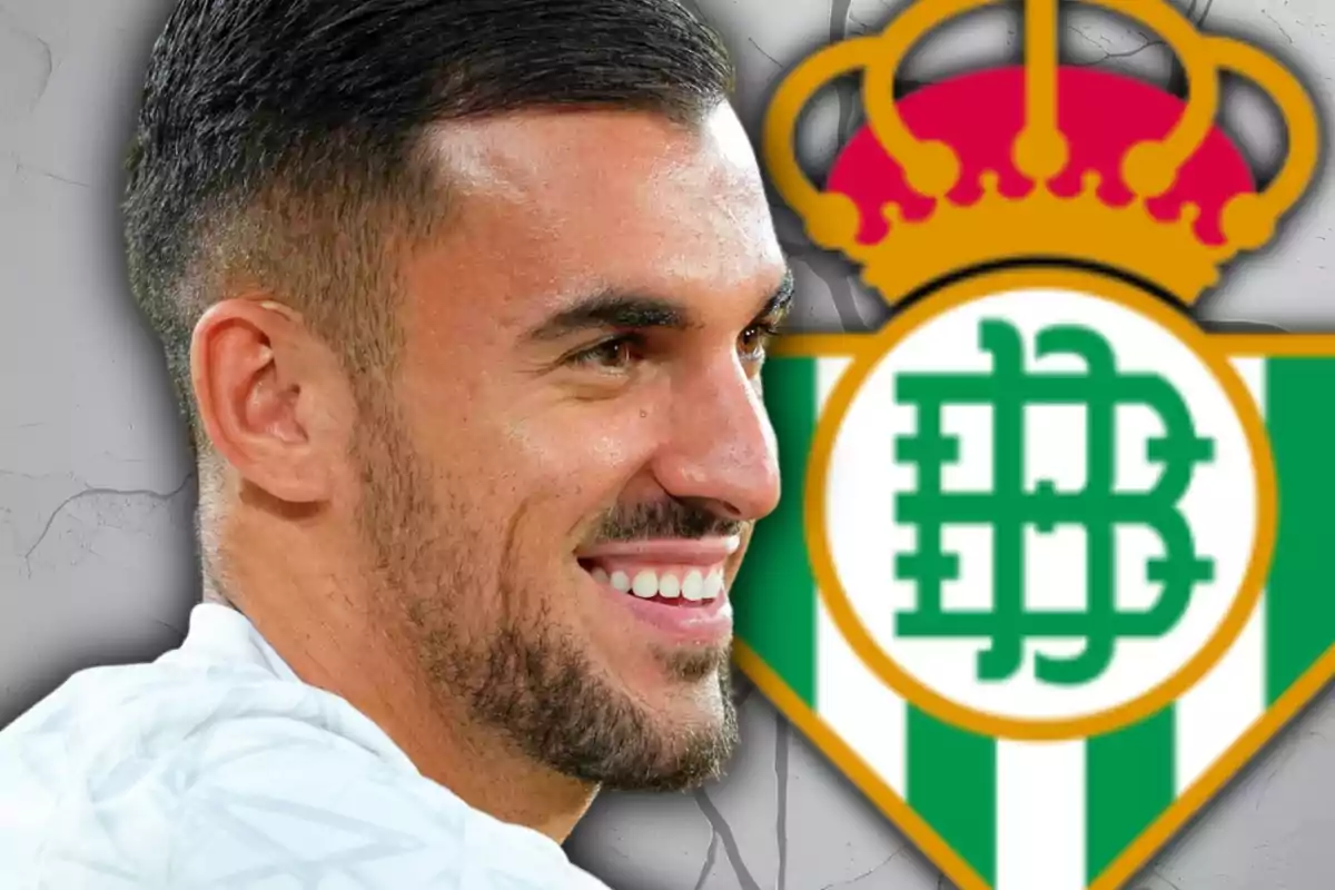 Home somrient amb barba davant de l'escut del Real Betis Home somrient amb barba davant de l'escut del Real Betis