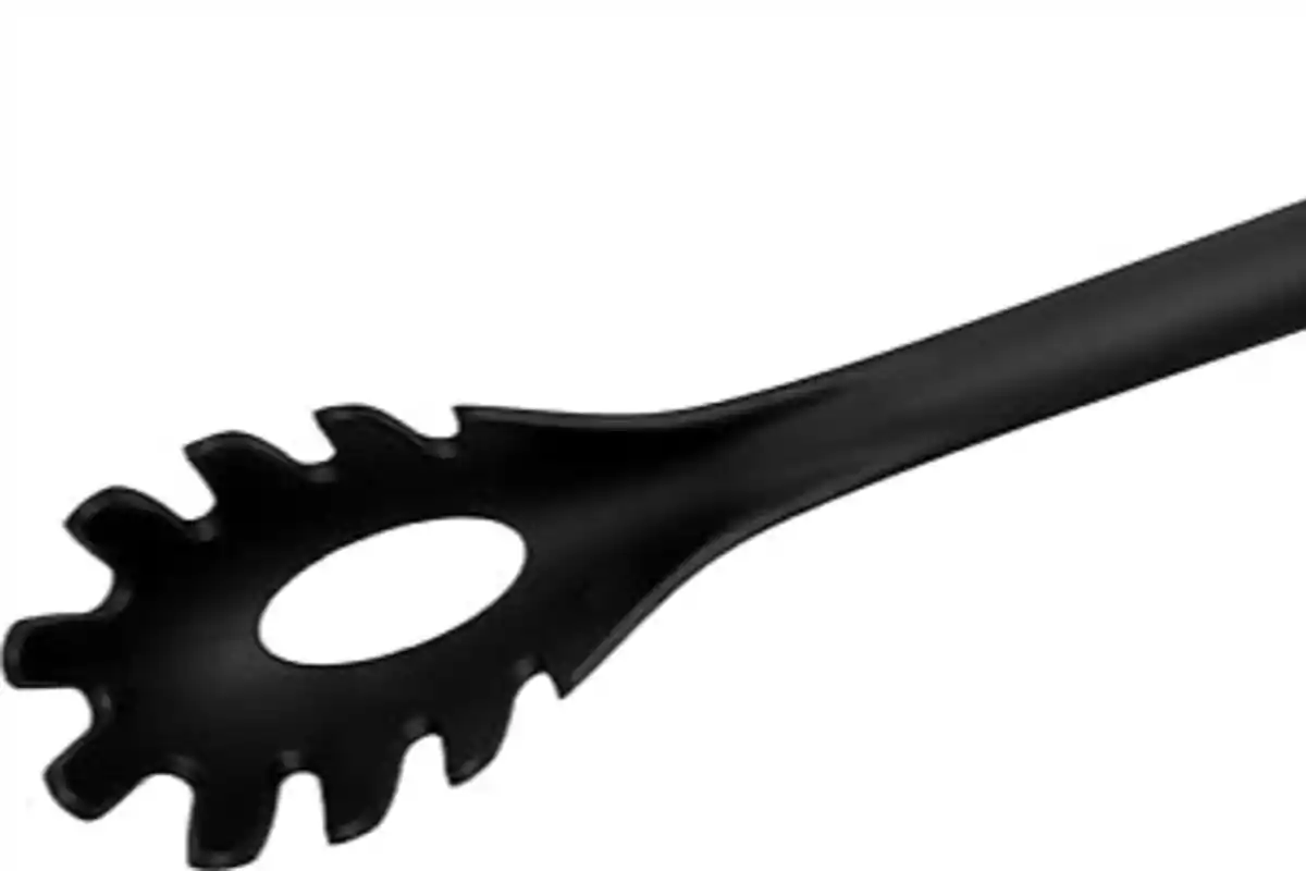 Utensilio negro para servir pasta con dientes alrededor y un agujero en el centro Utensilio negro para servir pasta con dientes alrededor y un agujero en el centro