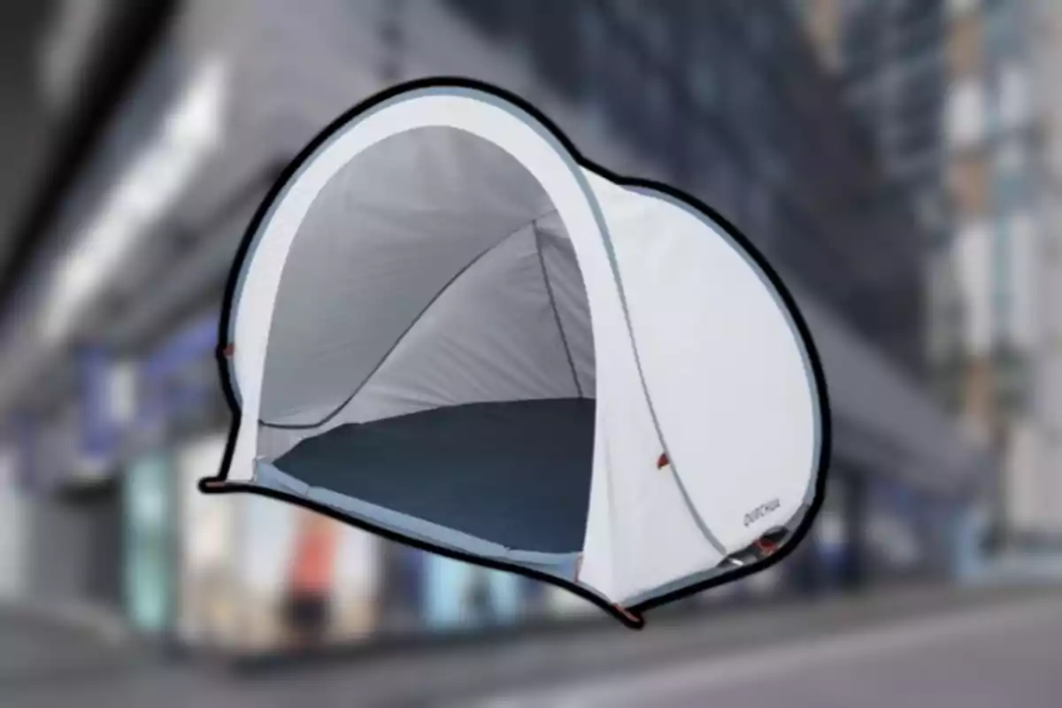 Tenda de campanya blanca tipus iglú sobre un fons urbà desenfocat Tenda de campanya blanca tipus iglú sobre un fons urbà desenfocat