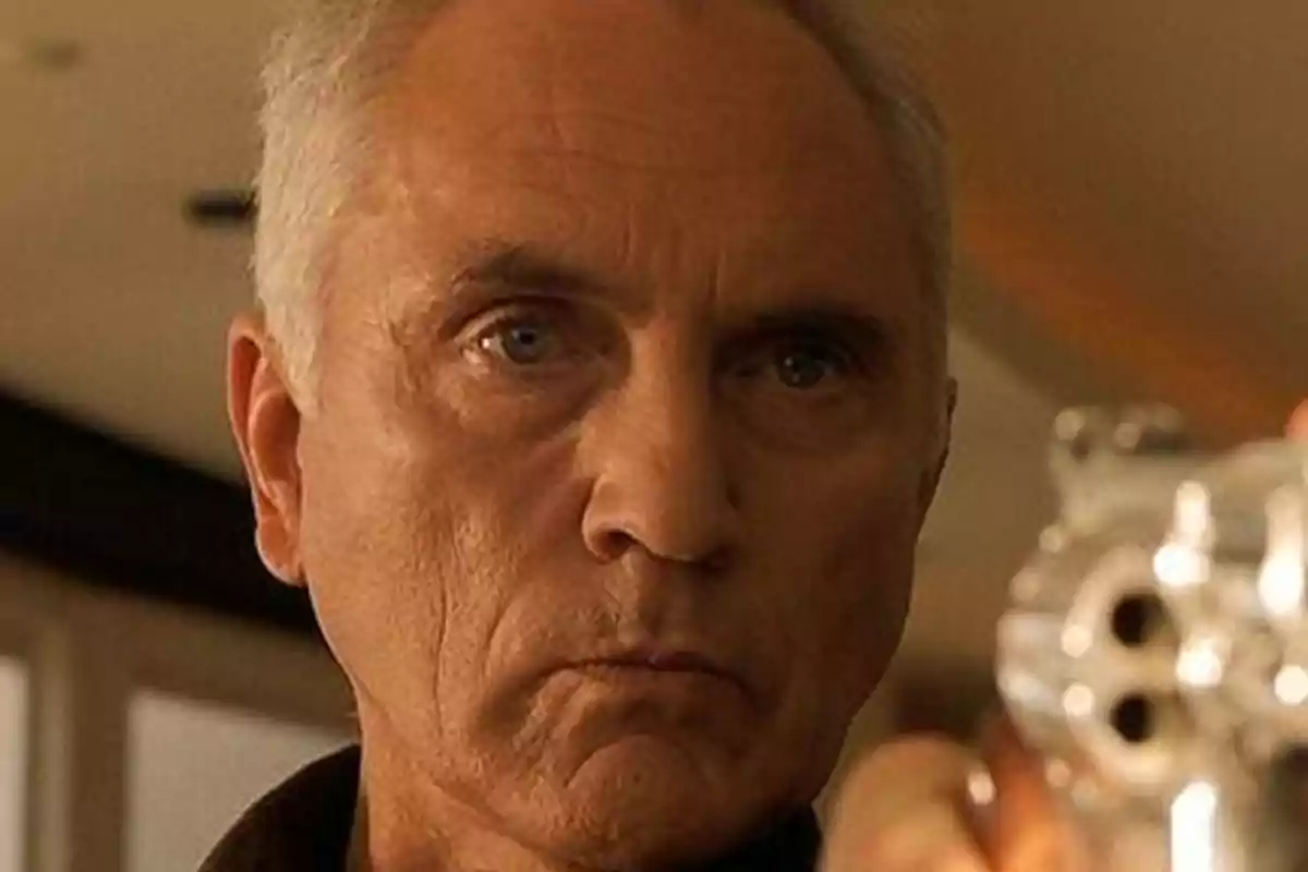 Terence Stamp amb expressió seriosa sostenint una pistola platejada apuntant cap al davant. Captura de 'El Falcó Anglès' Terence Stamp amb expressió seriosa sostenint una pistola platejada apuntant cap al davant. Captura de 'El Falcó Anglès'