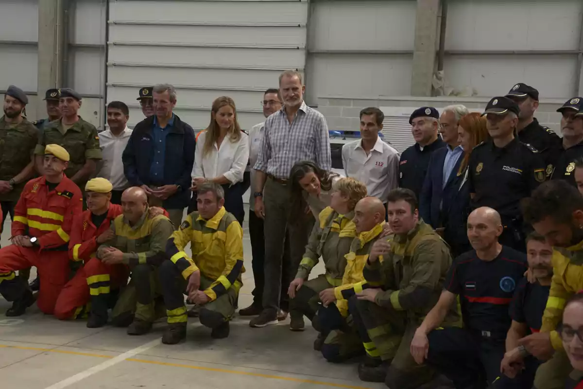 A group of firefighters, police officers, and emergency personnel pose together inside an industrial building. A group of firefighters, police officers, and emergency personnel pose together inside an industrial building.