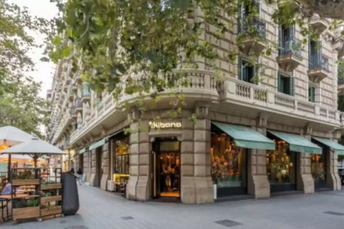 Restaurante en la esquina de un edificio elegante con terrazas y árboles en la acera Restaurante en la esquina de un edificio elegante con terrazas y árboles en la acera