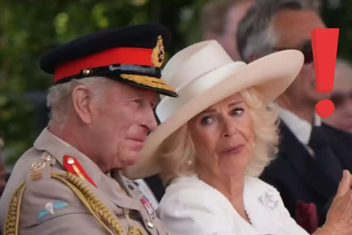 Parella de persones grans elegantment vestides, una amb uniforme militar i l’altra amb barret blanc, al costat d’un gran signe d’exclamació vermell. Parella de persones grans elegantment vestides, una amb uniforme militar i l’altra amb barret blanc, al costat d’un gran signe d’exclamació vermell.