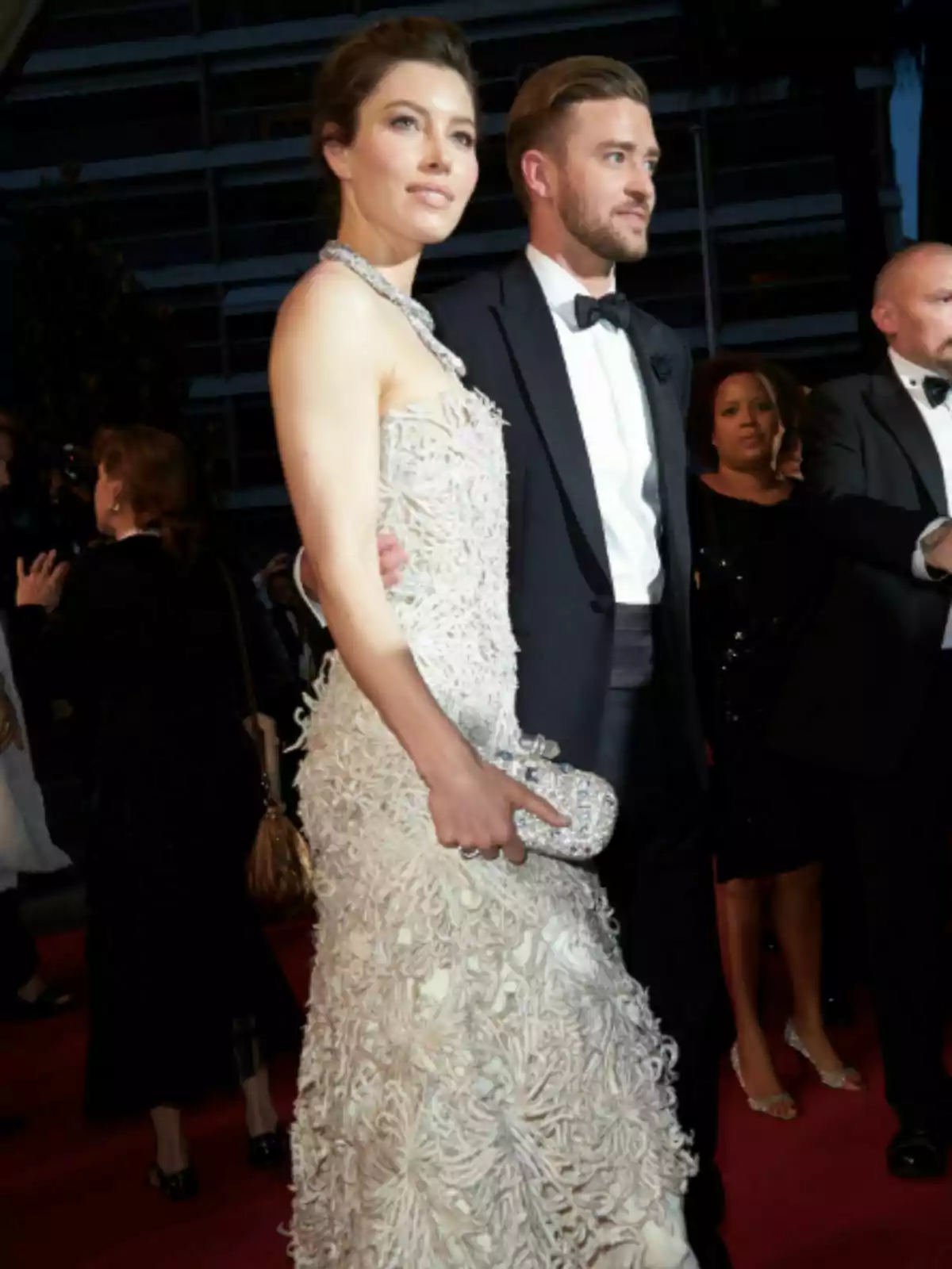 Jessica Biel i Justin Timberlake elegantment vestits posant en una catifa vermella envoltats d'altres persones en un esdeveniment nocturn Jessica Biel i Justin Timberlake elegantment vestits posant en una catifa vermella envoltats d'altres persones en un esdeveniment nocturn