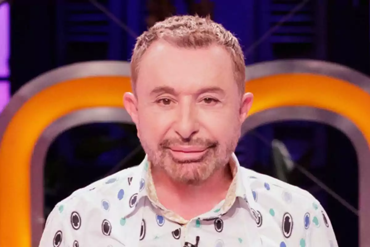 José Manuel Parada de cabello corto y barba recortada con camisa estampada de círculos en un set de MasterChef Celebrity iluminado con luces naranjas y fondo oscuro José Manuel Parada de cabello corto y barba recortada con camisa estampada de círculos en un set de MasterChef Celebrity iluminado con luces naranjas y fondo oscuro