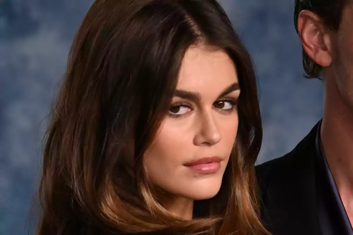 Kaia Gerber mirant cap a un costat amb expressió seriosa i fons blau desenfocat Kaia Gerber mirant cap a un costat amb expressió seriosa i fons blau desenfocat