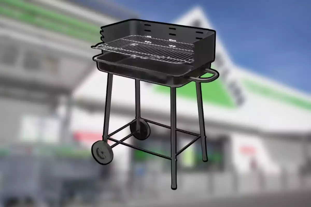 Barbacoa de carbó negra amb rodes i mànec davant d’un fons desenfocat d’una botiga Barbacoa de carbó negra amb rodes i mànec davant d’un fons desenfocat d’una botiga