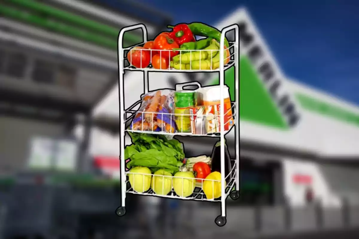 Carro organitzador de metall amb fruites, verdures i productes de rebost davant d’una botiga Carro organitzador de metall amb fruites, verdures i productes de rebost davant d’una botiga