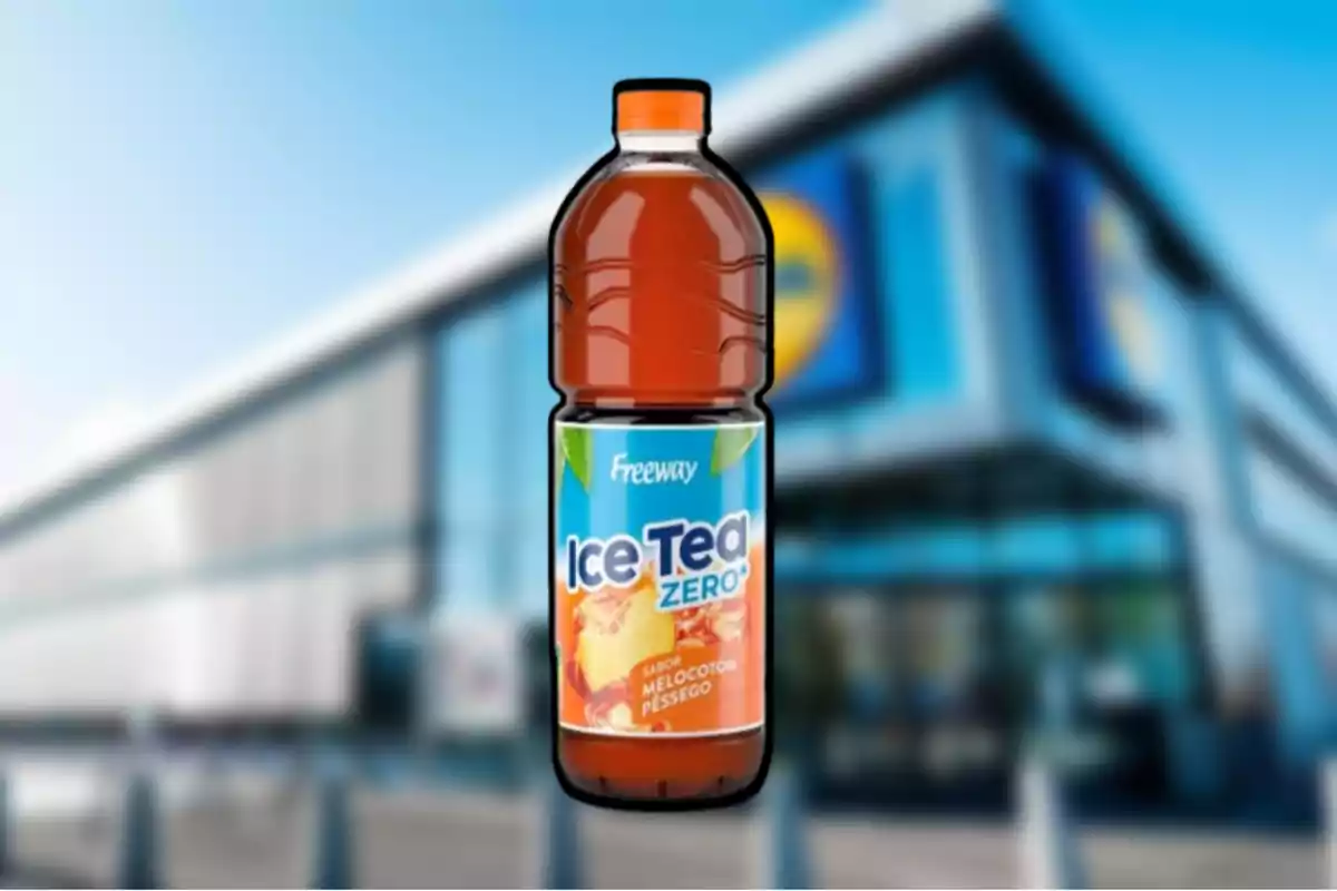 Ampolla de te gelat sabor préssec de la marca Freeway davant d’un supermercat desenfocat Ampolla de te gelat sabor préssec de la marca Freeway davant d’un supermercat desenfocat