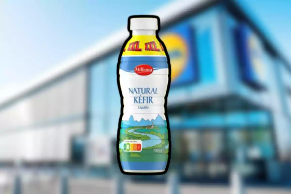 Ampolla de quefir natural de la marca Milbona en primer pla amb un supermercat desenfocat al fons