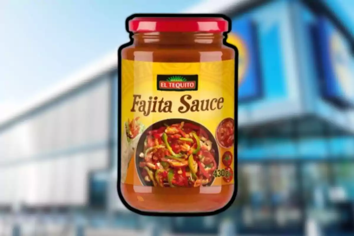 Pot de salsa per a fajitas de la marca El Tequito amb tapa vermella i etiqueta groga, al fons s’observa un edifici desenfocat. Pot de salsa per a fajitas de la marca El Tequito amb tapa vermella i etiqueta groga, al fons s’observa un edifici desenfocat.