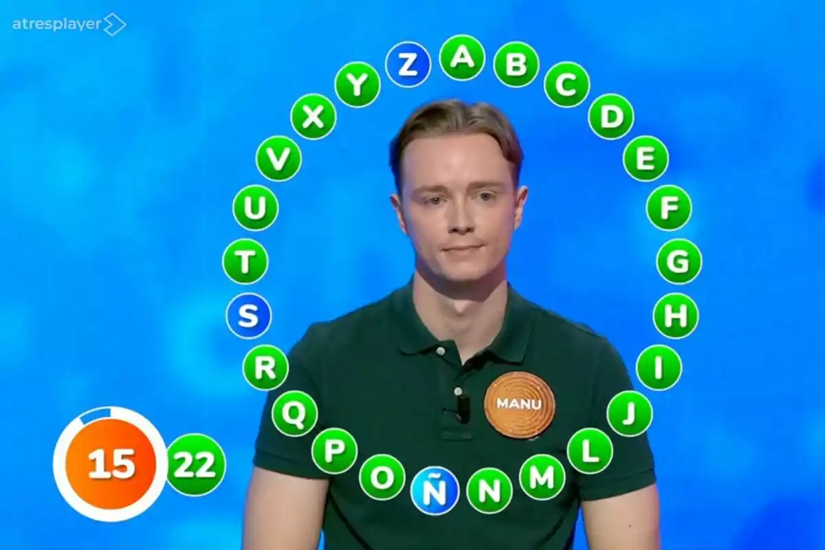 Un concursant de 'Pasapalabra', que és Manu Pascual, està participant en la prova del rosco, envoltat de lletres en cercle, amb un marcador de temps i encerts a la cantonada inferior esquerra. Un concursant de 'Pasapalabra', que és Manu Pascual, està participant en la prova del rosco, envoltat de lletres en cercle, amb un marcador de temps i encerts a la cantonada inferior esquerra.