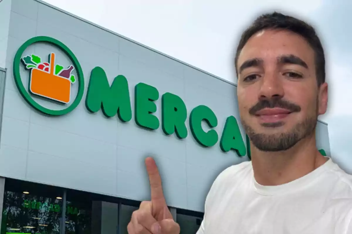 Hombre con barba y camiseta blanca señalando el letrero de un supermercado Mercadona