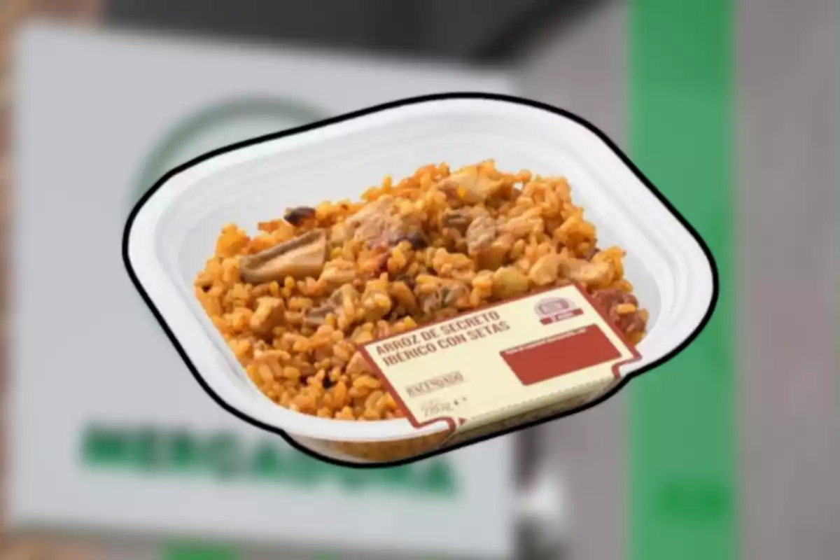 Envàs d’arròs de secret ibèric amb bolets de supermercat sobre fons desenfocat Envàs d’arròs de secret ibèric amb bolets de supermercat sobre fons desenfocat