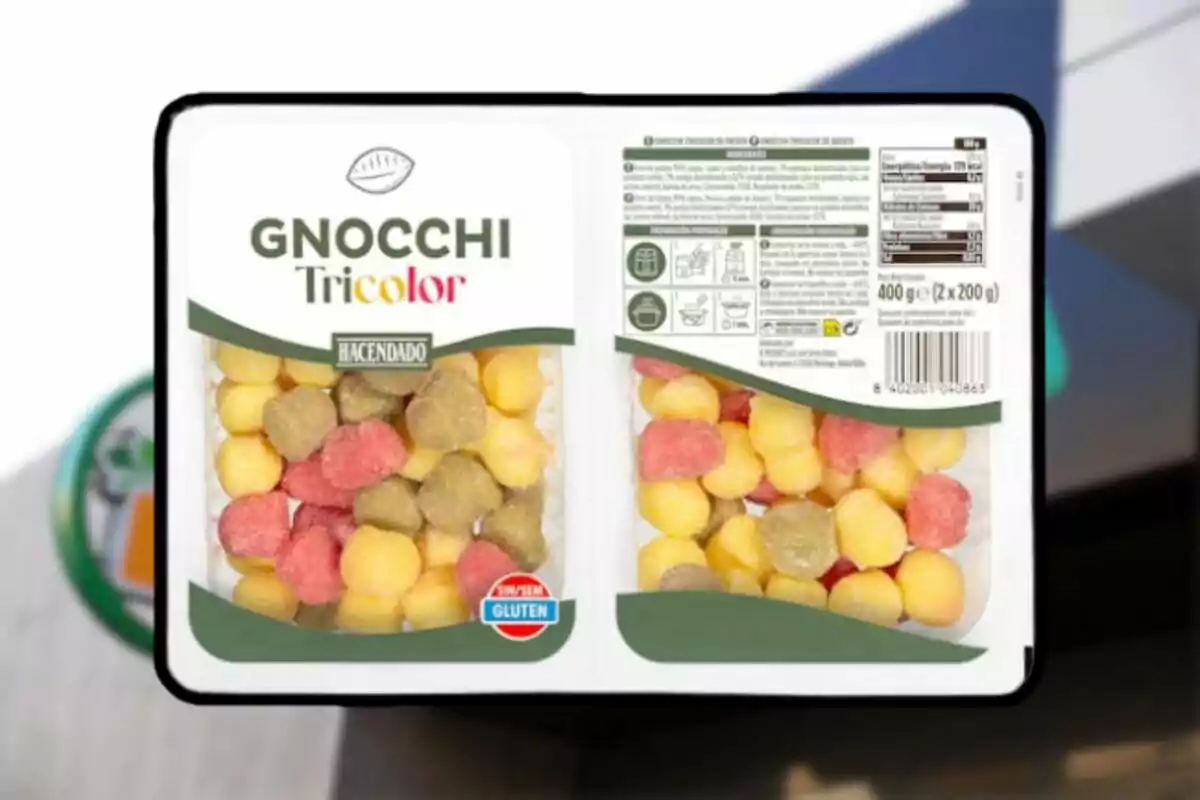 Envase de gnocchi tricolor de la marca Hacendado sin gluten con piezas de colores amarillo, verde y rojo visible a través del plástico transparente