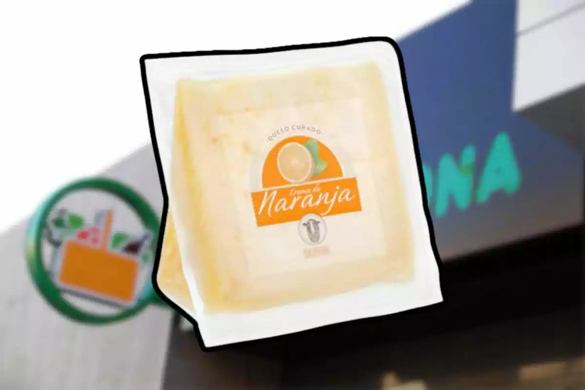 Queso curado crema de naranja en empaque transparente frente a una tienda