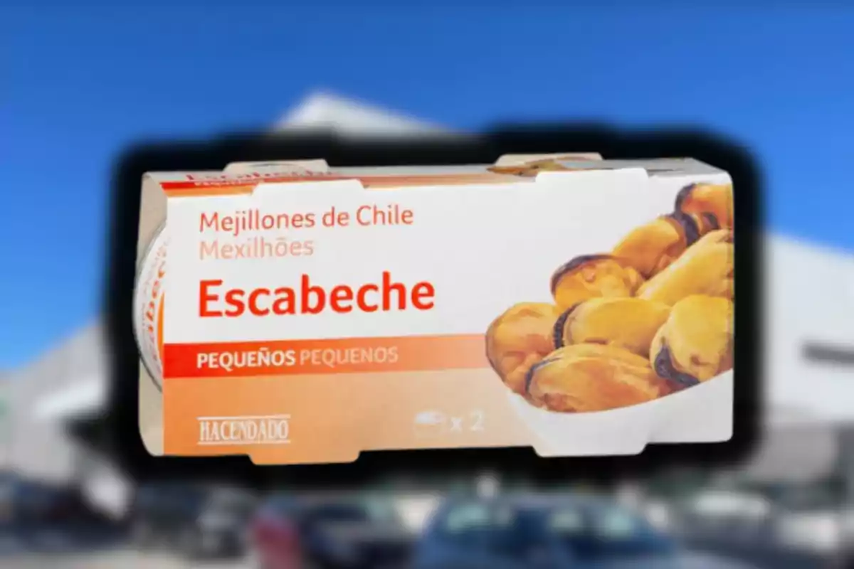 Caja de mejillones en escabeche marca Hacendado con fondo desenfocado de un supermercado y autos