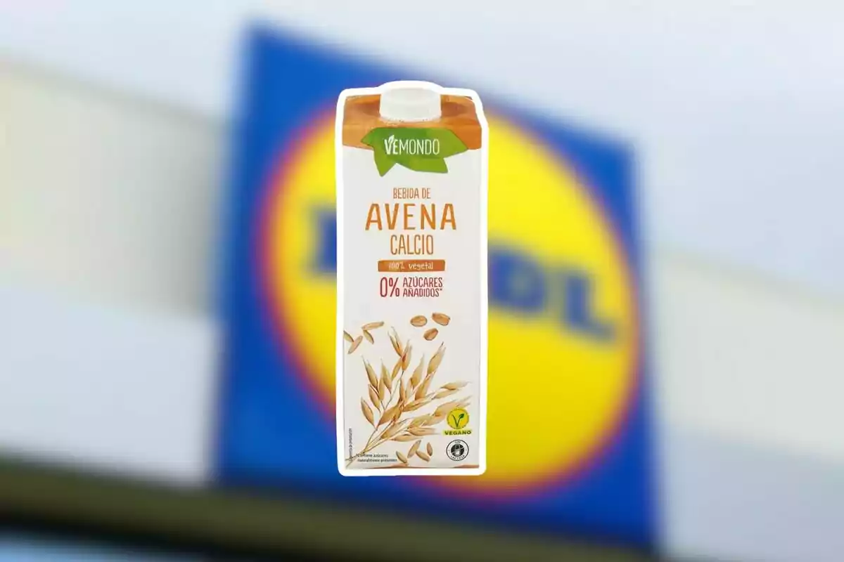 Envase de bebida de avena con calcio de la marca Vemondo frente a un cartel borroso de Lidl Envase de bebida de avena con calcio de la marca Vemondo frente a un cartel borroso de Lidl