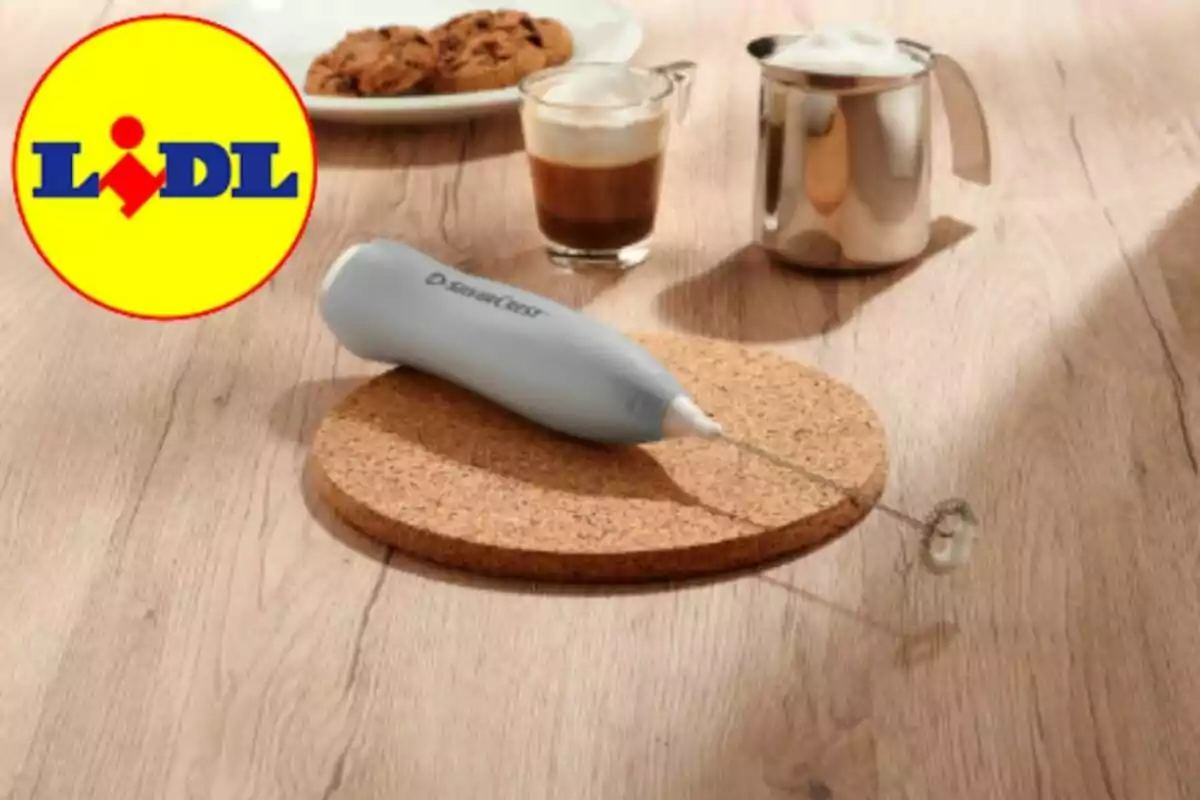 Batedora d’escuma de llet sobre una base de suro amb una tassa de cafè, una gerra de llet escumada i un plat de galetes al fons, al costat del logotip de Lidl
