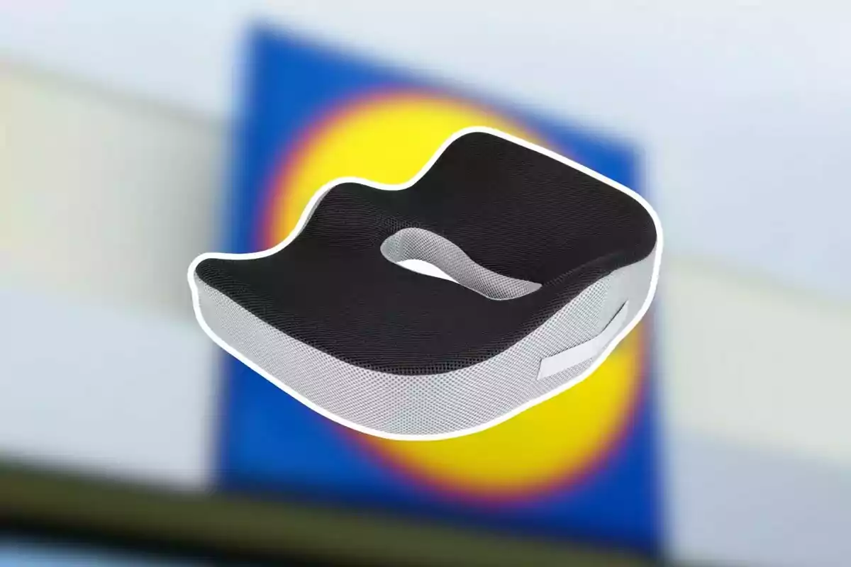 Coixí ergonòmic negre i gris amb un fons desenfocat d’un rètol blau i groc Coixí ergonòmic negre i gris amb un fons desenfocat d’un rètol blau i groc