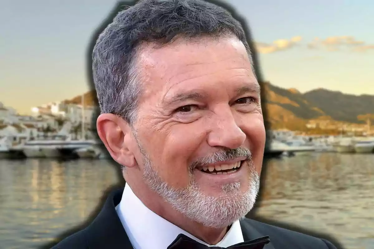 Antonio Banderas sonriendo con fondo de puerto y montañas al atardecer
