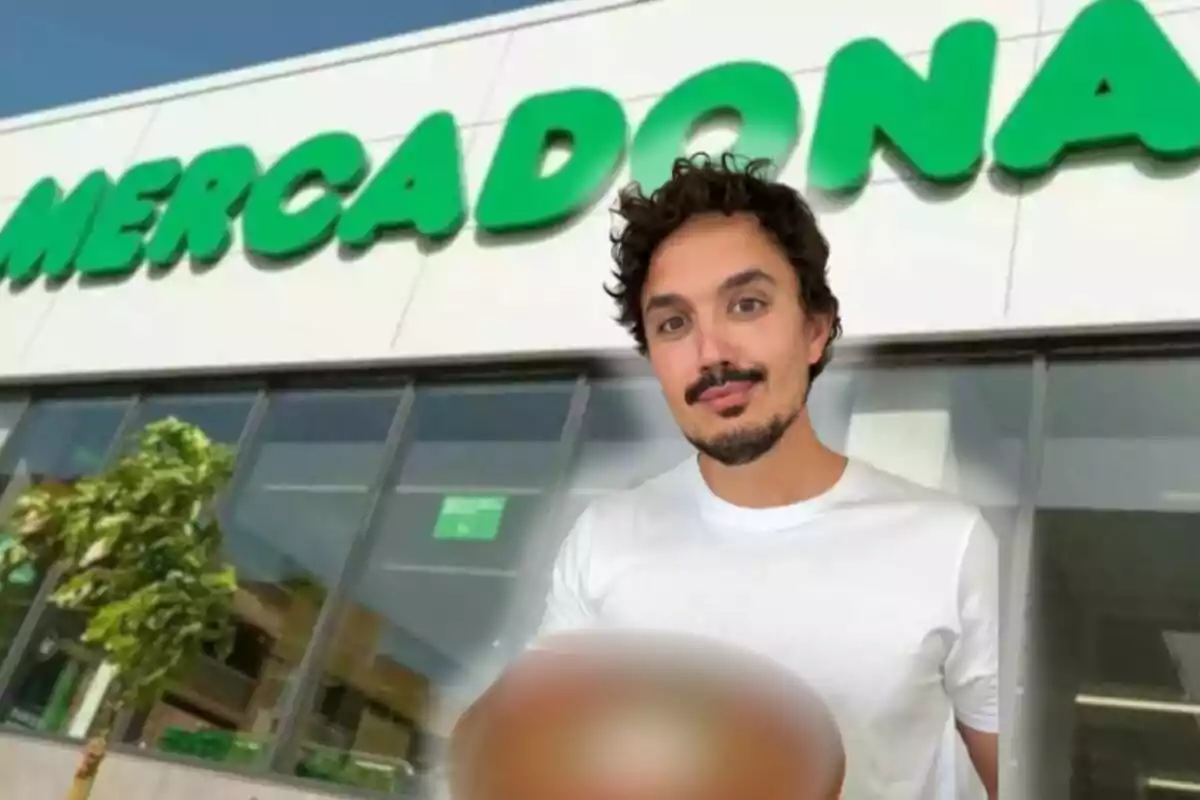 Hombre de cabello rizado y barba con camiseta blanca frente a una tienda Mercadona sosteniendo un objeto borroso