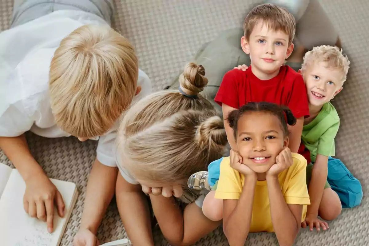 Un grupo de niños sonríe y juega juntos sobre una alfombra, algunos están acostados leyendo y otros posan felices mirando a la cámara. Un grupo de niños sonríe y juega juntos sobre una alfombra, algunos están acostados leyendo y otros posan felices mirando a la cámara.