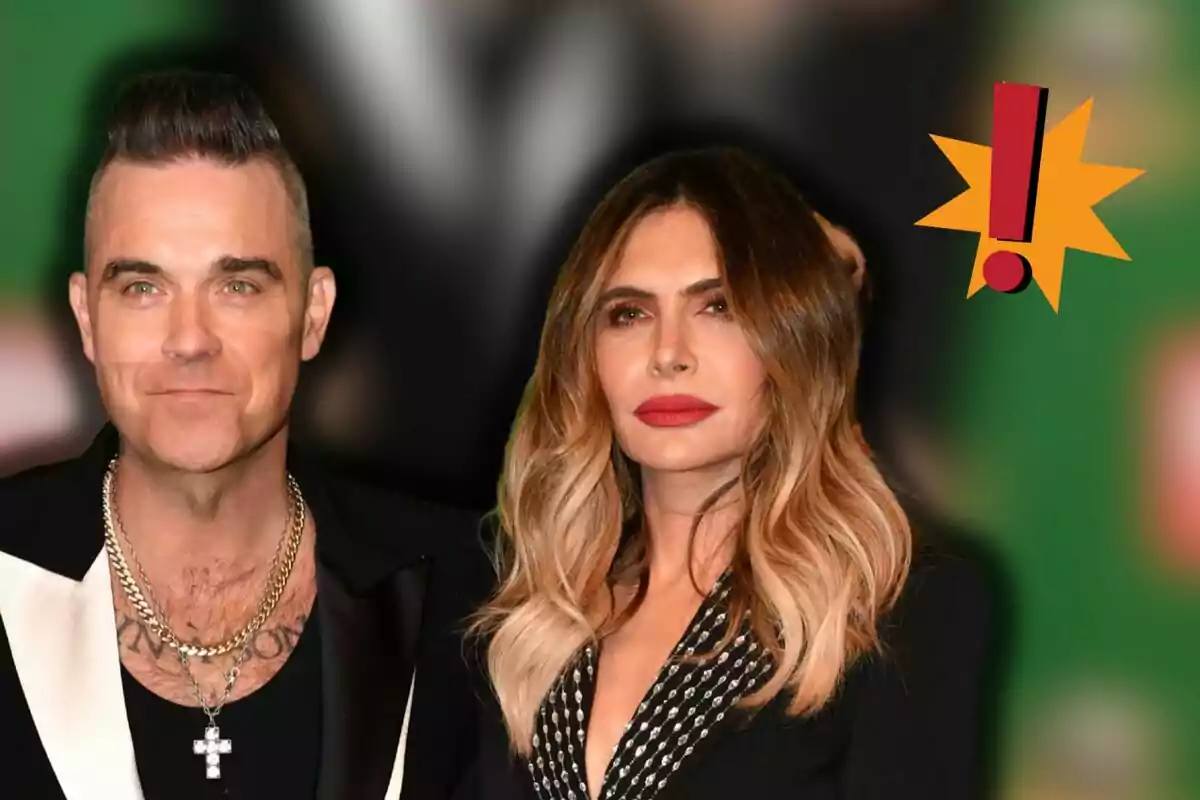 Robbie Williams and Ayda Field posing together at an event with a blurred background and an exclamation mark in the corner