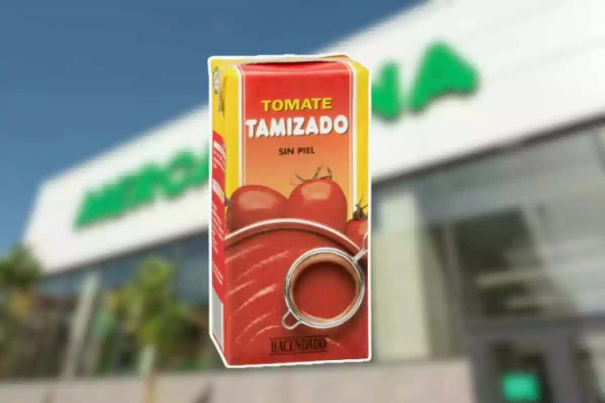 Envase de tomate tamizado sin piel de la marca Hacendado frente a un supermercado desenfocado