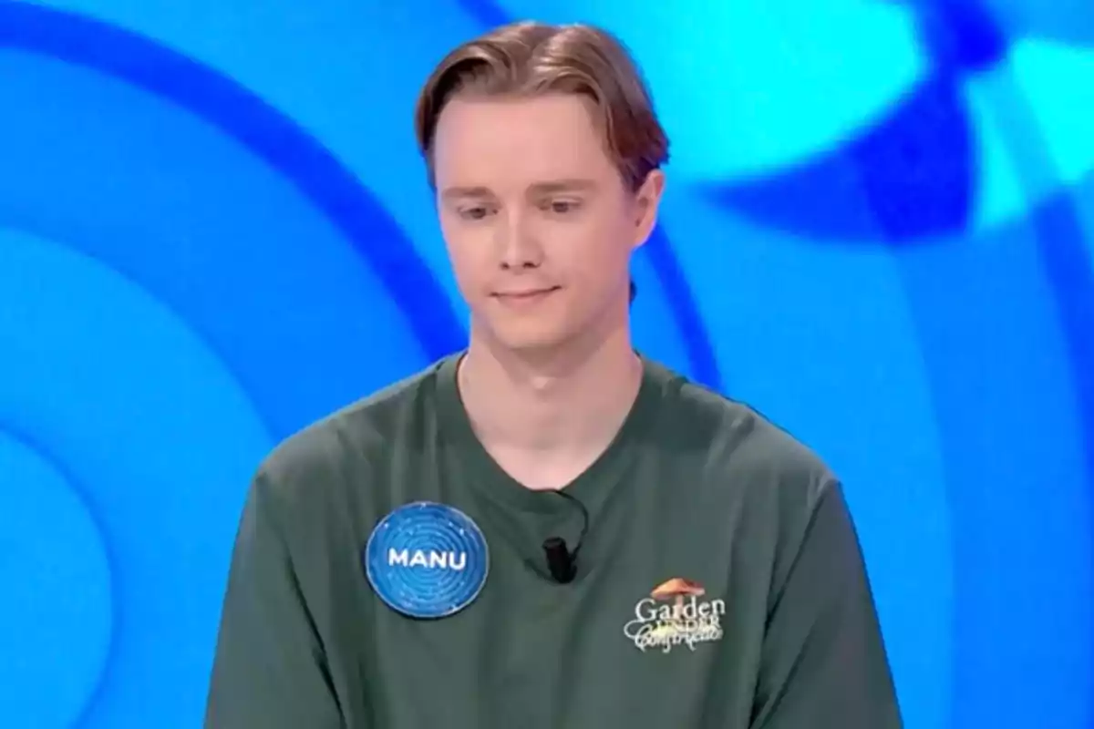 Manu amb samarreta verda i placa identificativa en un programa de televisió amb fons blau. Captura de 'Pasapalabra'