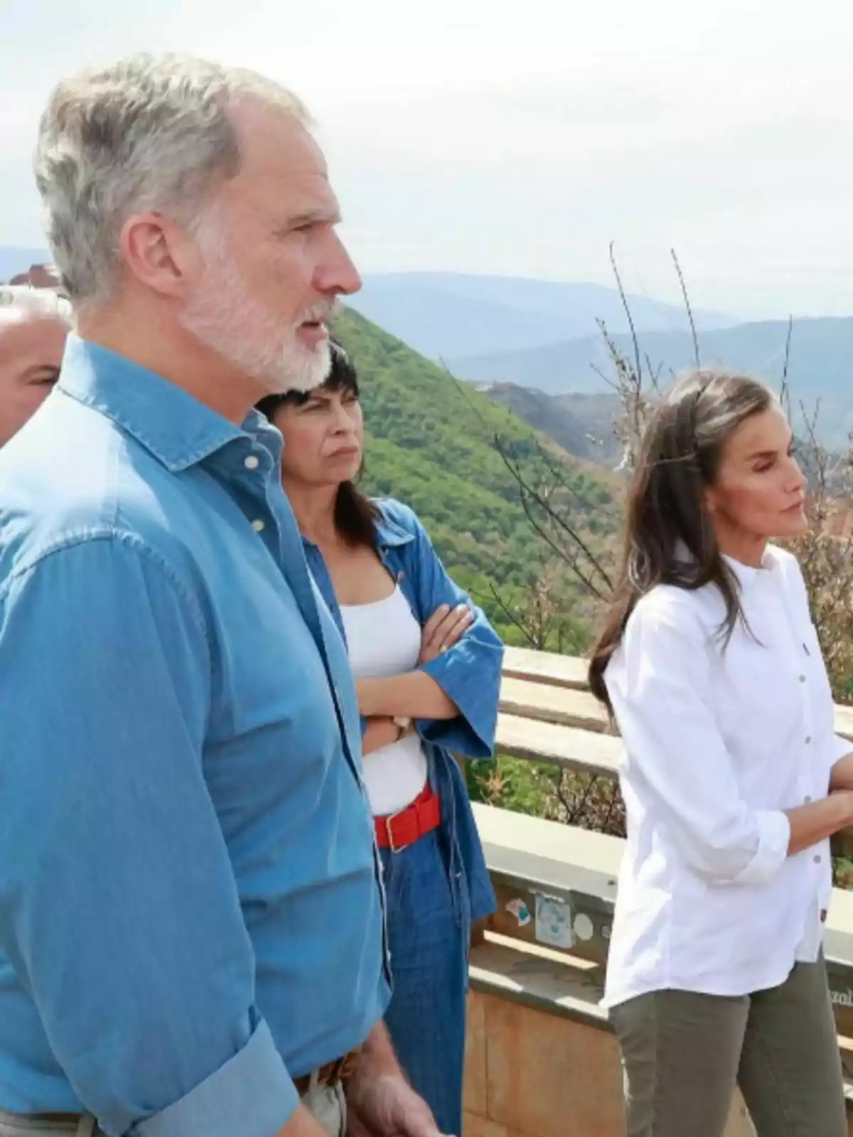 Several people observe the mountainous landscape outdoors on a sunny day. Several people observe the mountainous landscape outdoors on a sunny day.
