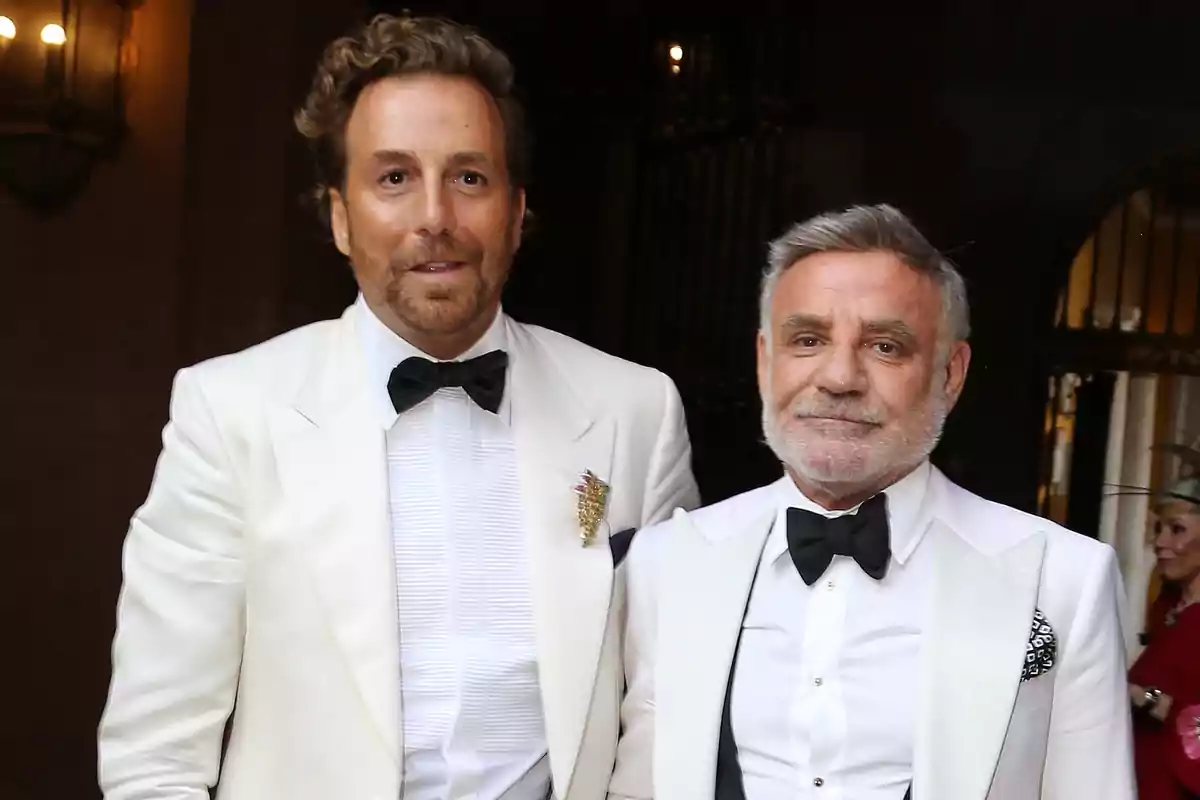 Raúl Prieto y Joaquín Torres vestidos con esmoquin blanco y pajarita negra posan juntos en un evento elegante
