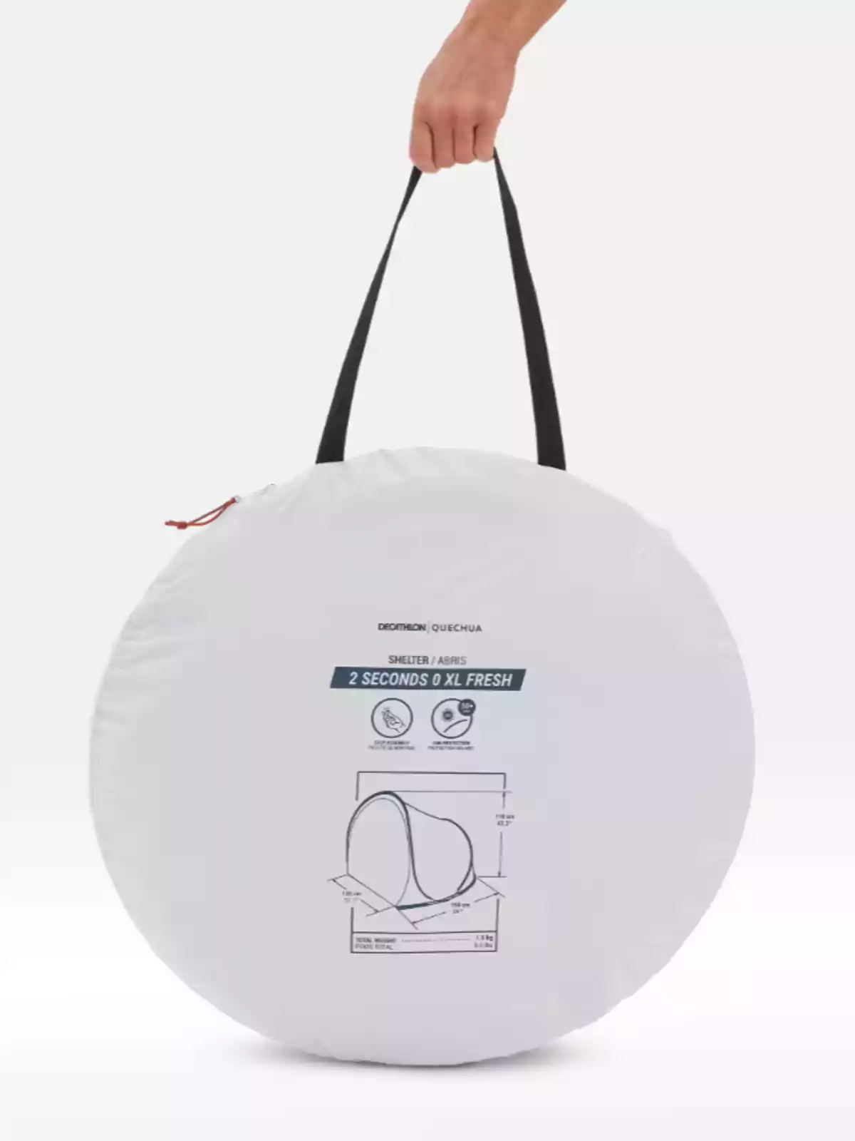 Persona sostenint una funda circular blanca amb nansa negra que conté una tenda de campanya portàtil Persona sostenint una funda circular blanca amb nansa negra que conté una tenda de campanya portàtil