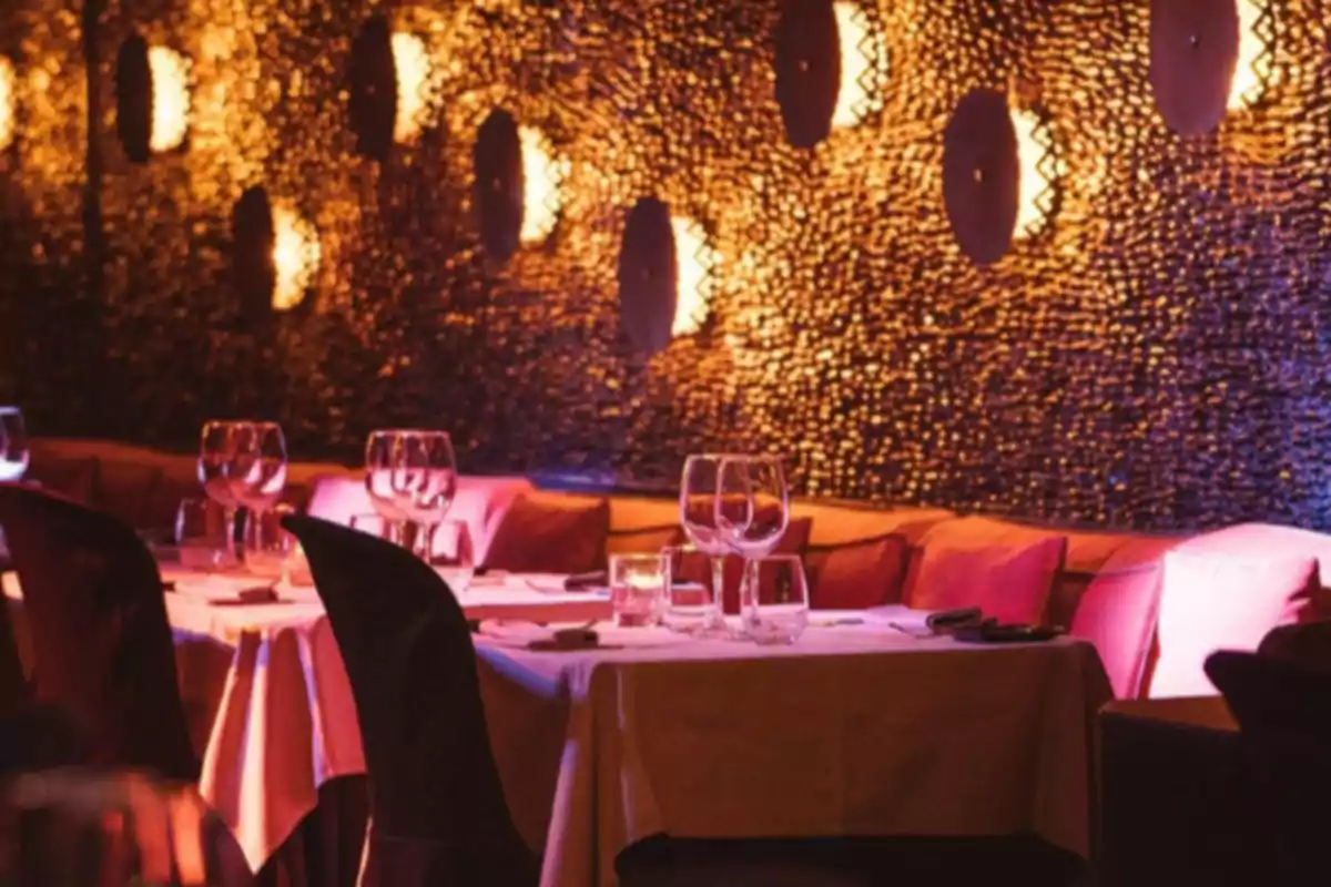 Elegant restaurant with dressed tables, wine glasses, and warm ambient lighting Elegant restaurant with dressed tables, wine glasses, and warm ambient lighting